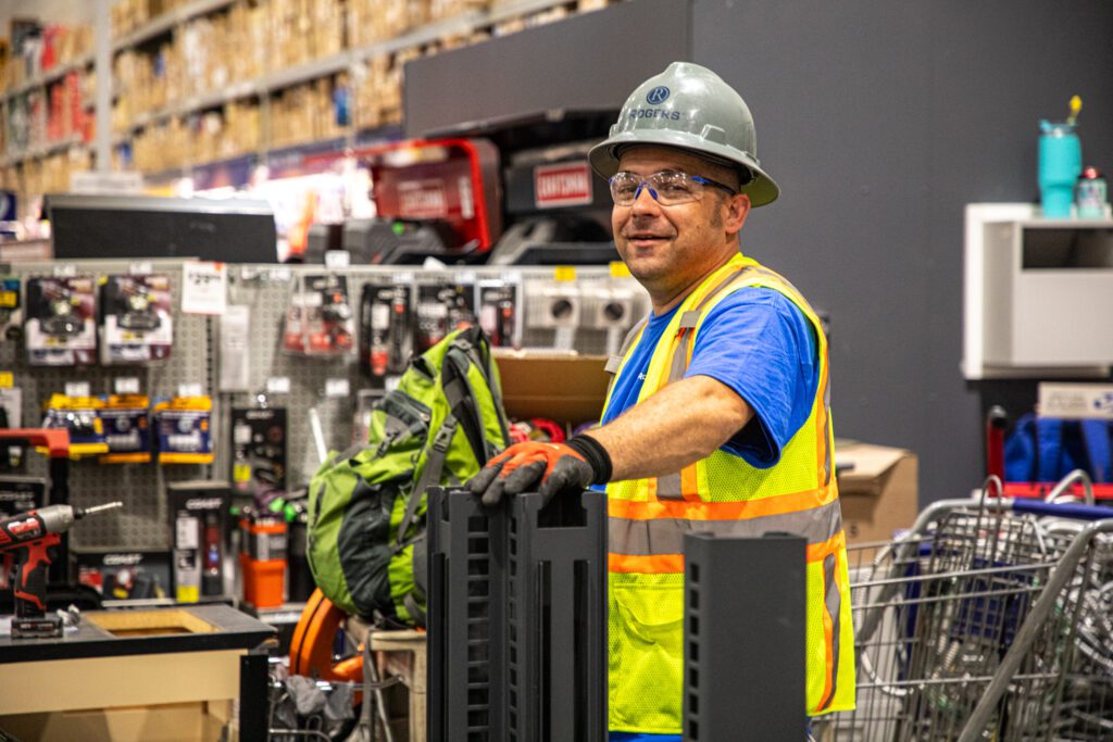 electrician smiling at the camera with PPE gear on inside a Home Depot