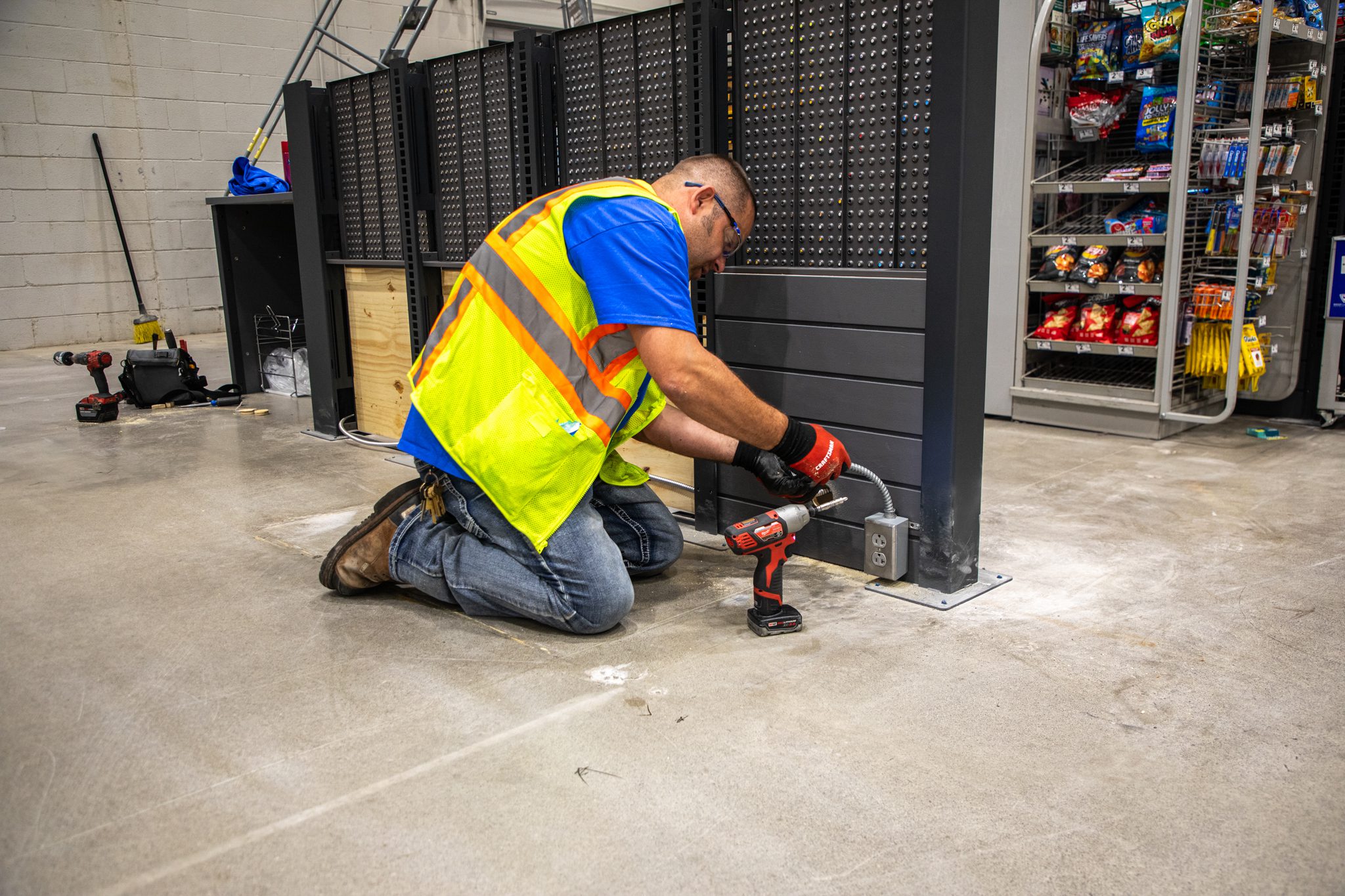 Technician connecting to new power box before installing self-checkout machine.