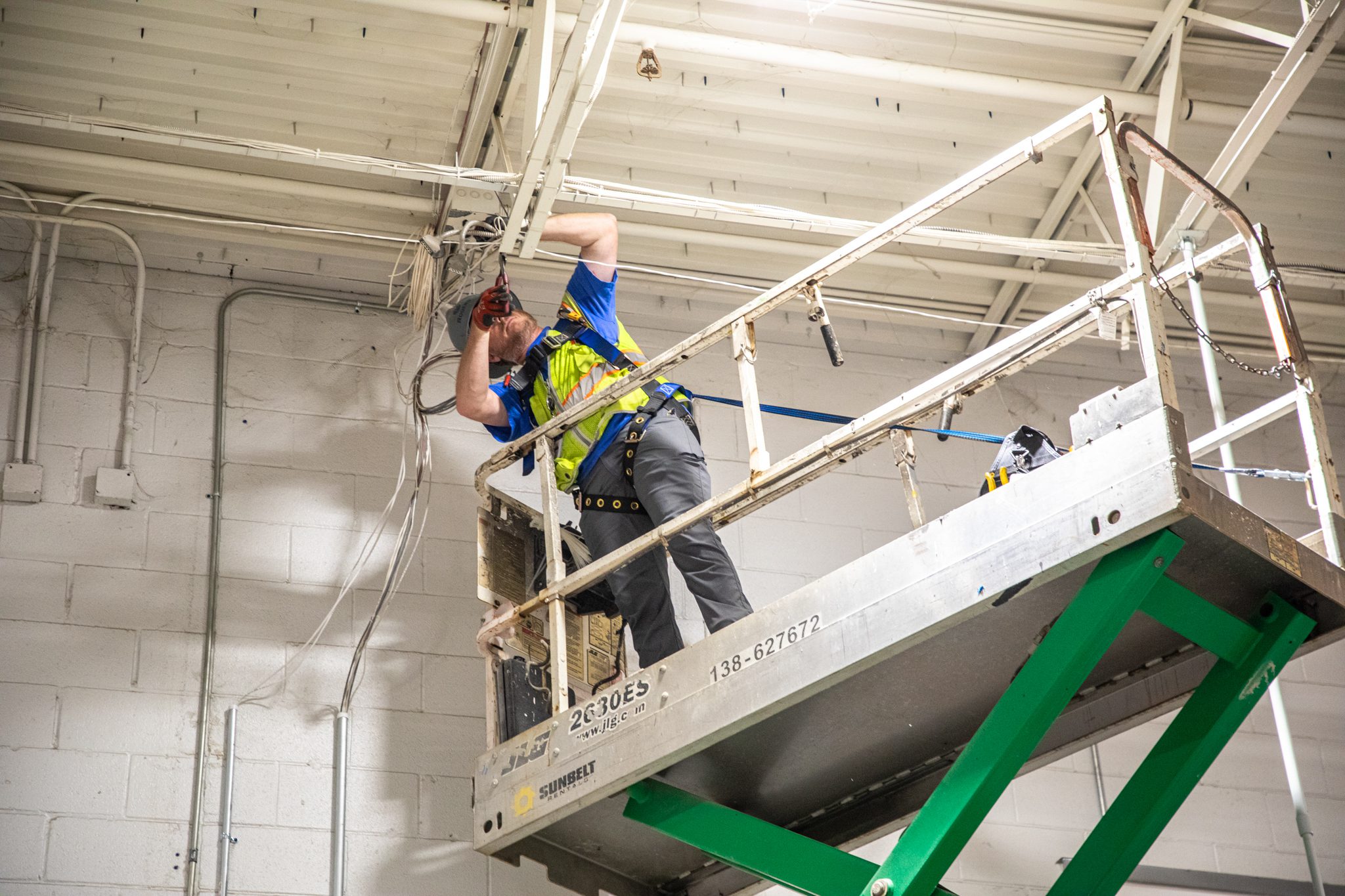 Technician on lift installing power box.