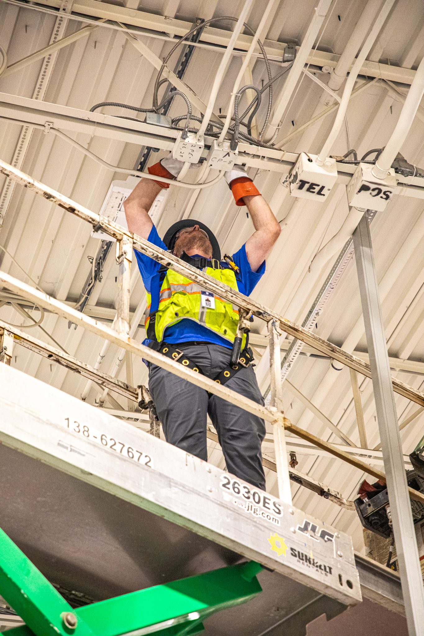 Technician on lift preparing power box before adding new power pole.