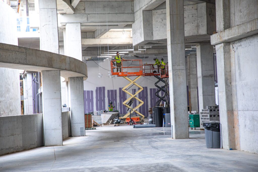 multiple techs on lifts inside of a construction site of a building 